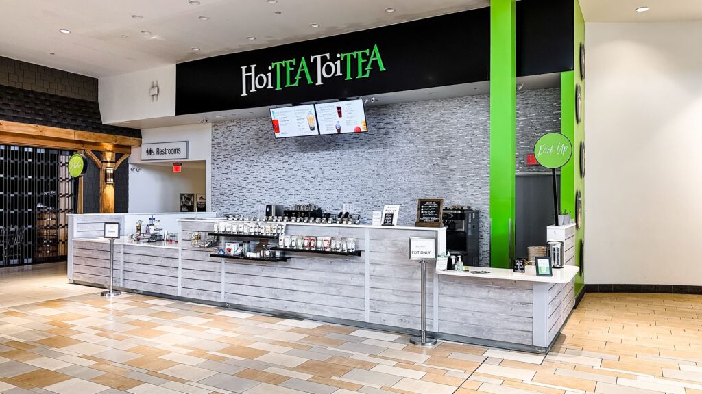 Wide view of HoiTea ToiTea retail shop showcasing bright interior design and branding.