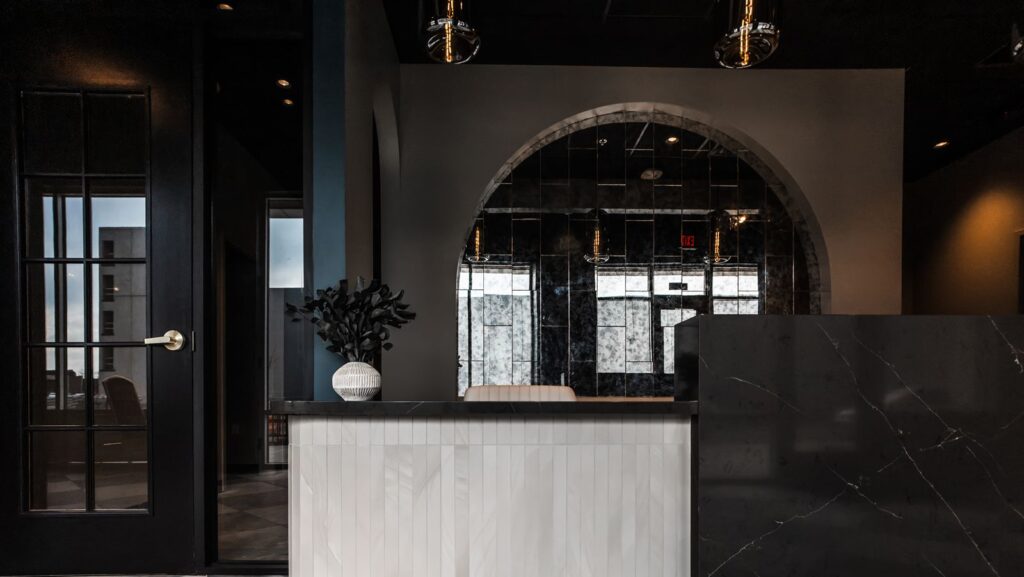 Hallway with sleek finishes and arched entryways leading to treatment rooms.