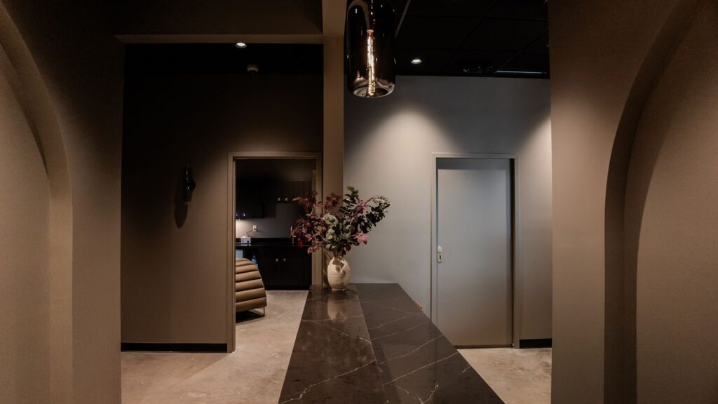 Waiting area with arched design elements, black marble finishes, and statement lighting.