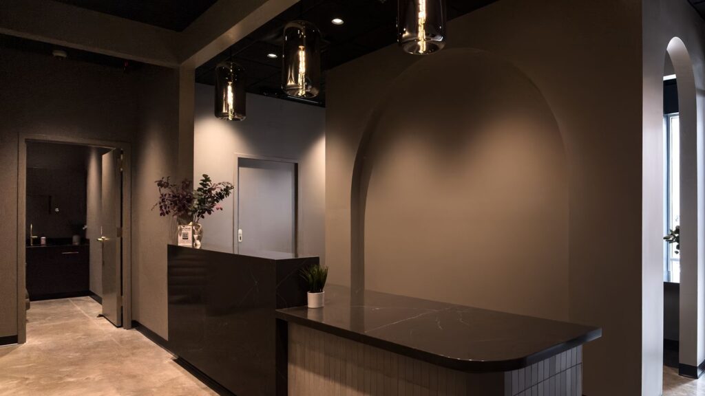 Waiting area with arched design elements, black marble finishes, and statement lighting.