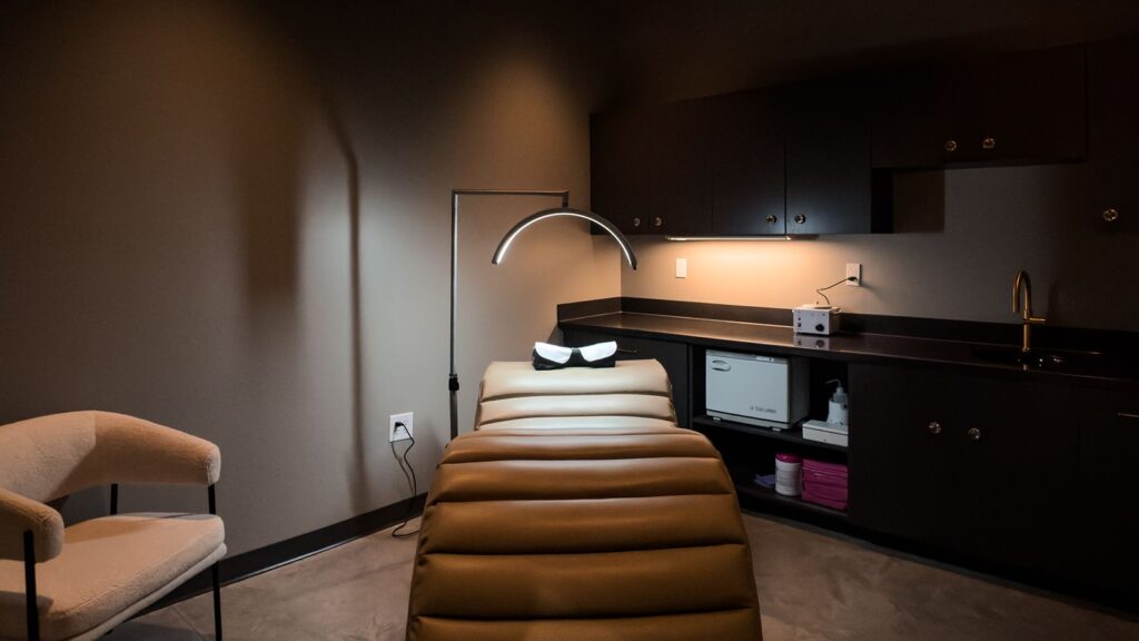Aesthetic treatment room featuring ergonomic recliner and minimal, moody interior design.