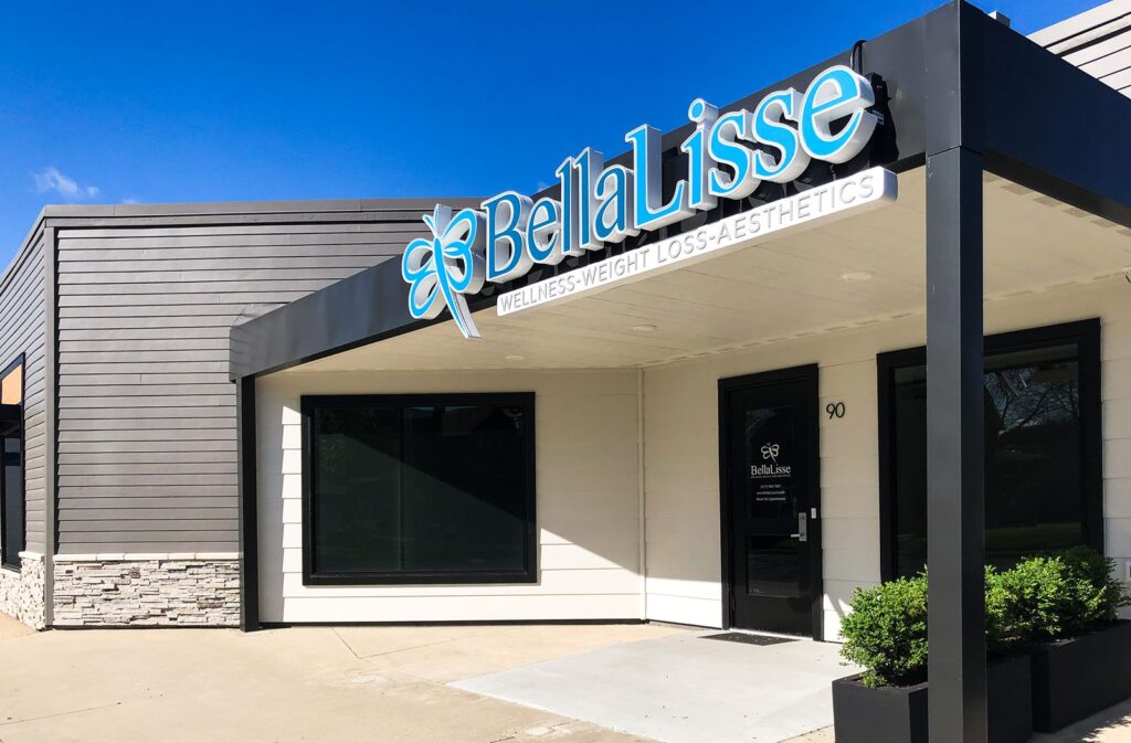 Front entry of Bella Lisse wellness and aesthetics office featuring modern signage and architectural lighting.