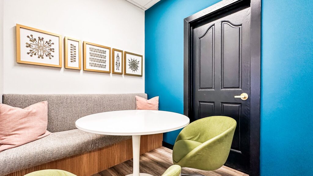 Seating nook with blue accent wall, modern furniture, and curated artwork.