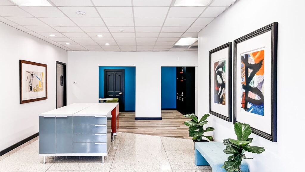 Reception area featuring terrazzo flooring, white walls, and mid-century furniture design.