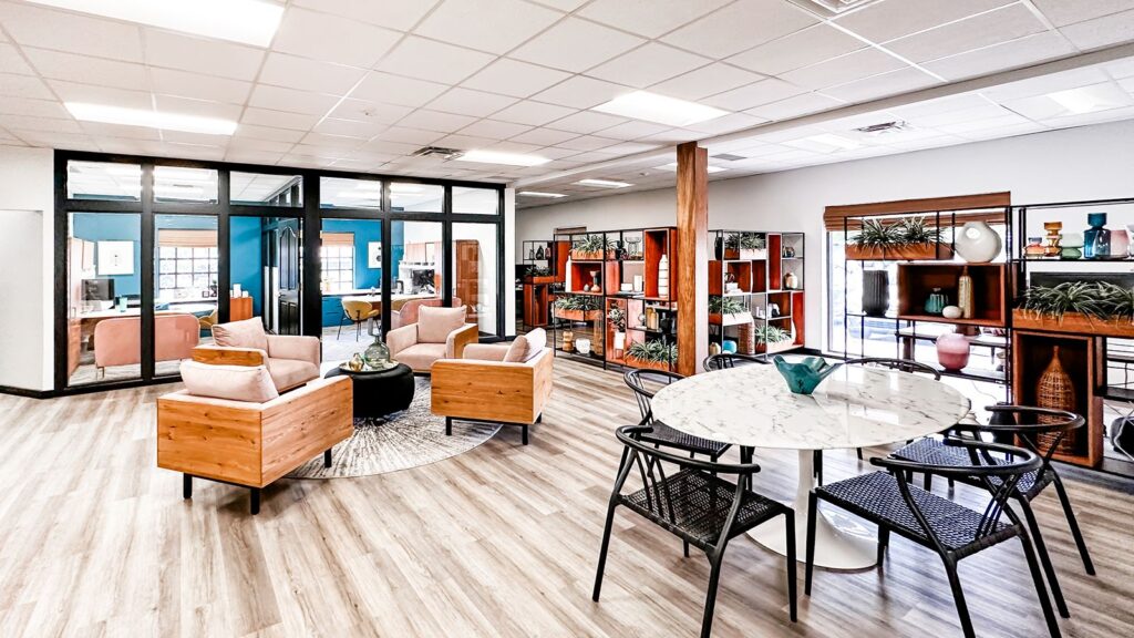 Collaborative office area with large windows, wood furniture, and modern seating.