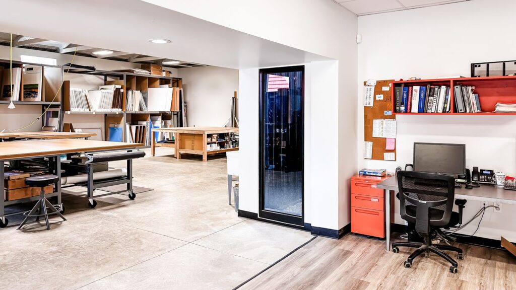 Hallway view featuring red lockers and access to framing workshop.