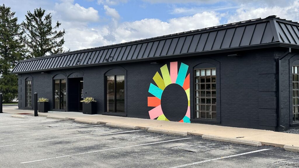 Exterior view of Insite Art Consultants building with bold mural and modern black facade.
