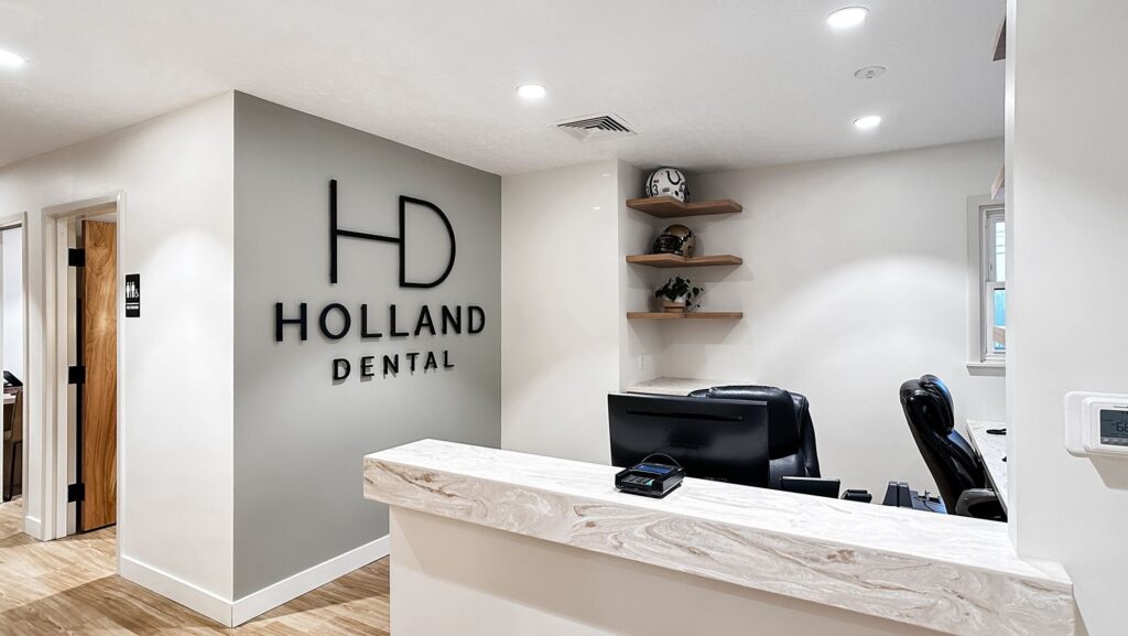 Reception area featuring marble countertop and Holland Dental logo in welcoming entry space.