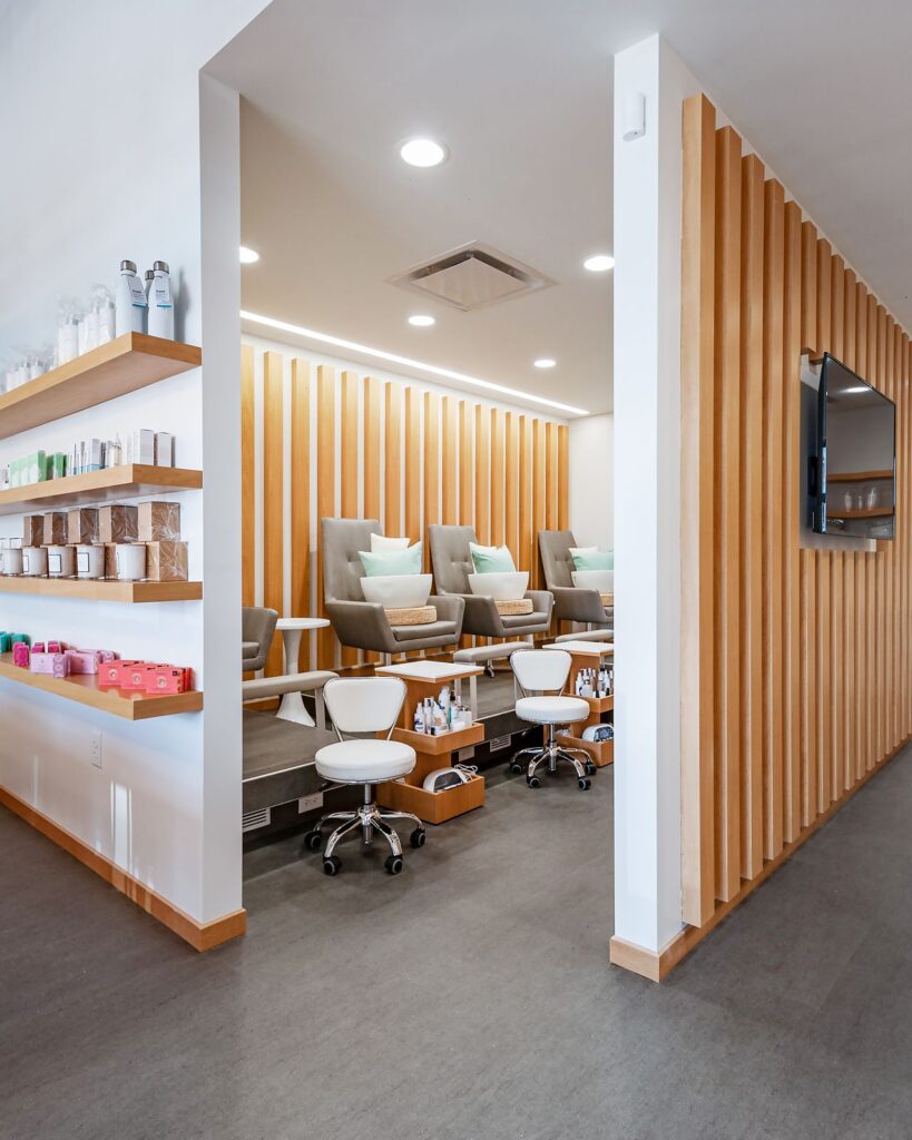 Interior design of PROSE Nails featuring light wood cabinetry and open shelving.