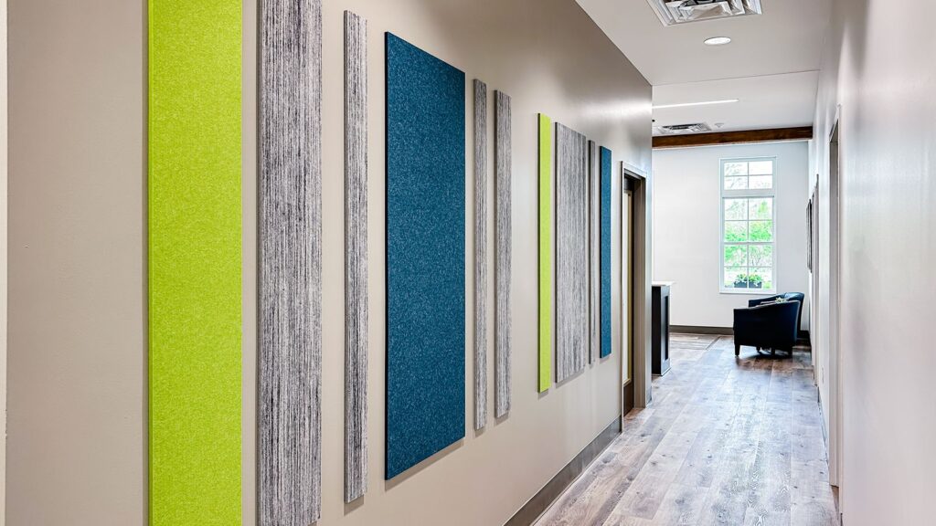 Hallway featuring colorful acoustic panels and modern flooring by commercial interior design Indianapolis professionals.
