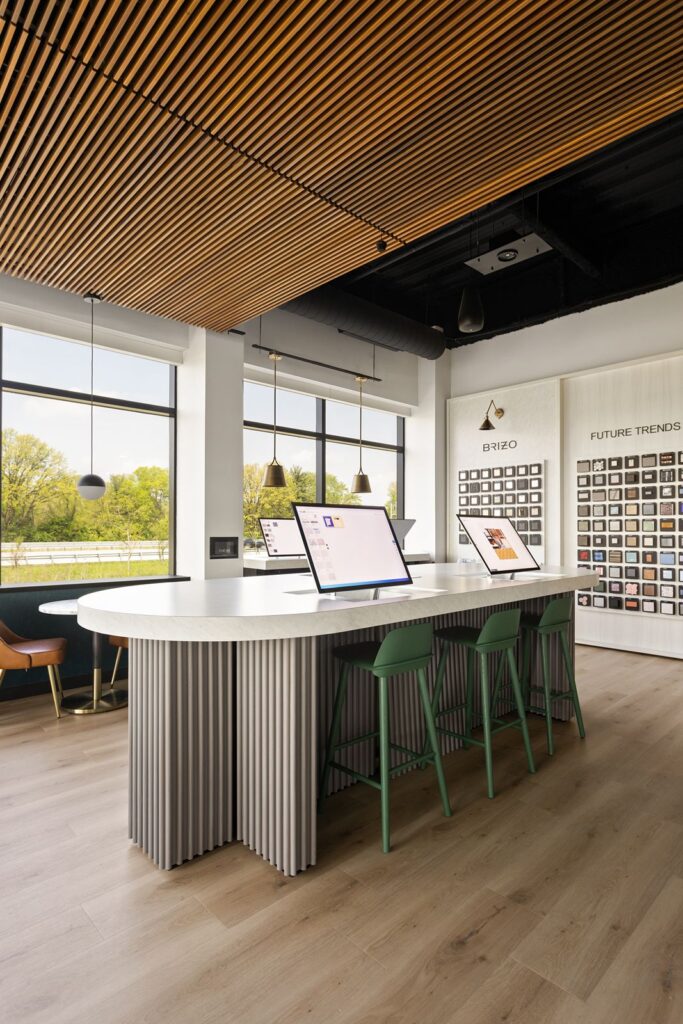 Round collaboration table surrounded by green stools in Delta Faucet’s modern showroom.