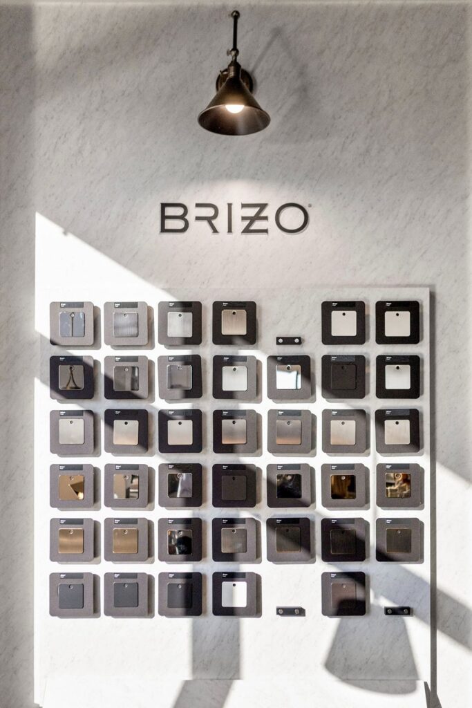 Display wall featuring Brizo fixture samples and custom lighting in modern design resource center.