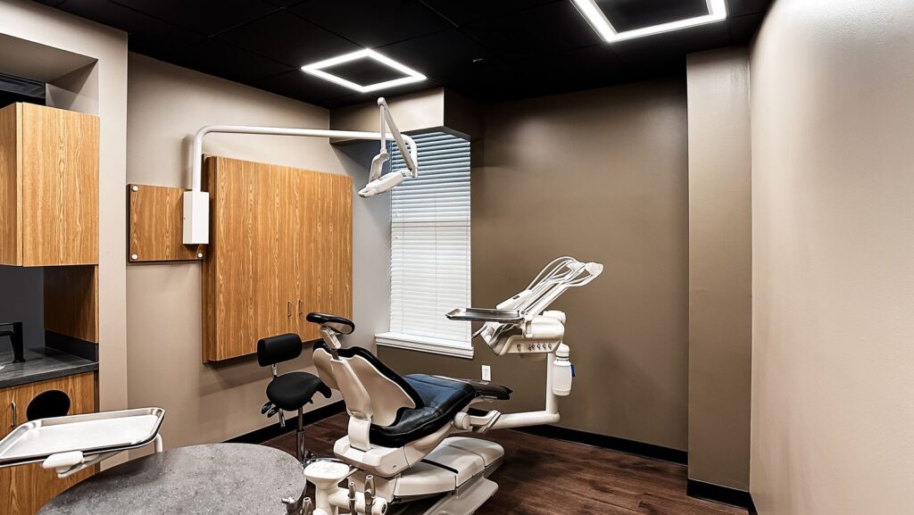 Exam room featuring overhead lighting and modern dental office remodel design.