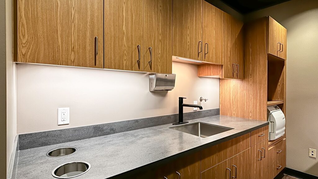 Sterilization room with wood cabinetry and functional dental office workflow design.