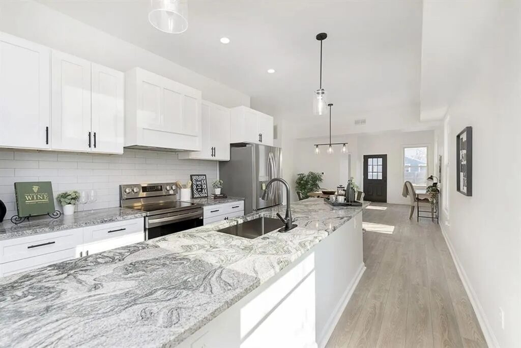 Open kitchen layout with gray cabinetry and modern lighting.
