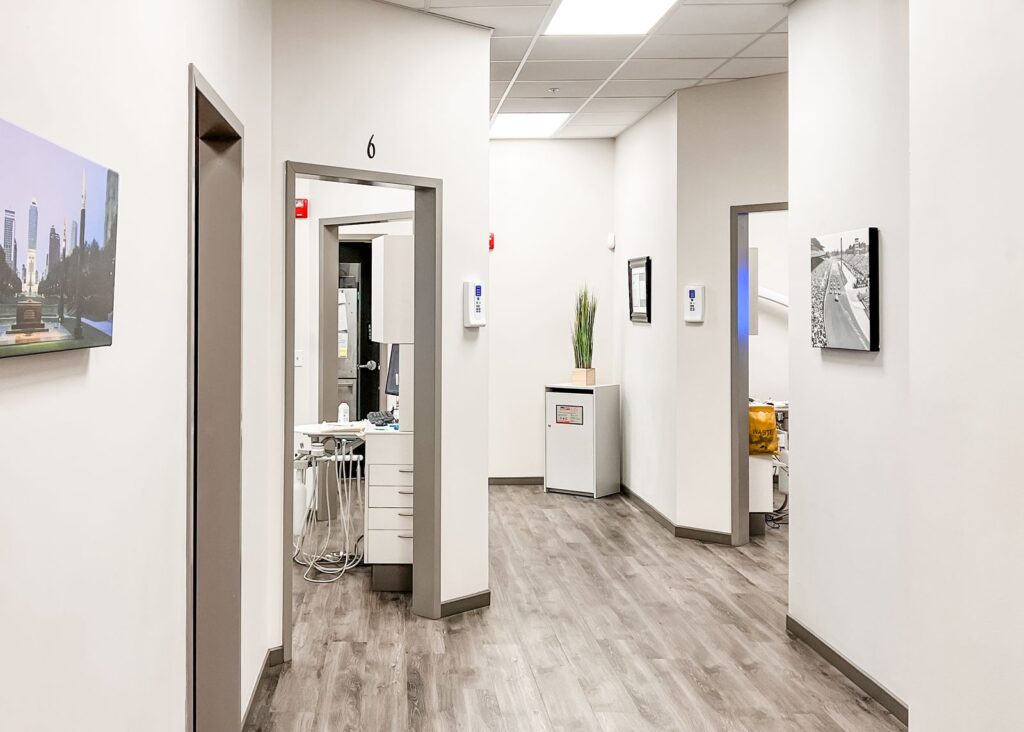 Exam room corridor with framed wall art and minimalist dental practice design.