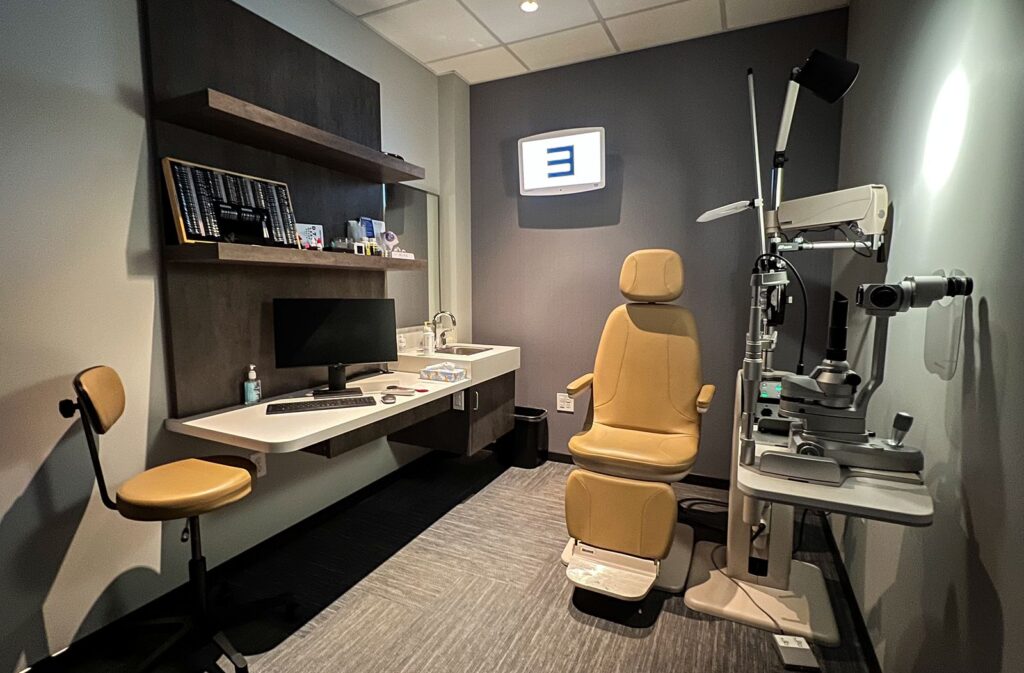 Private exam room with diagnostic chair and cabinetry showcasing optometry clinic interior design functionality.