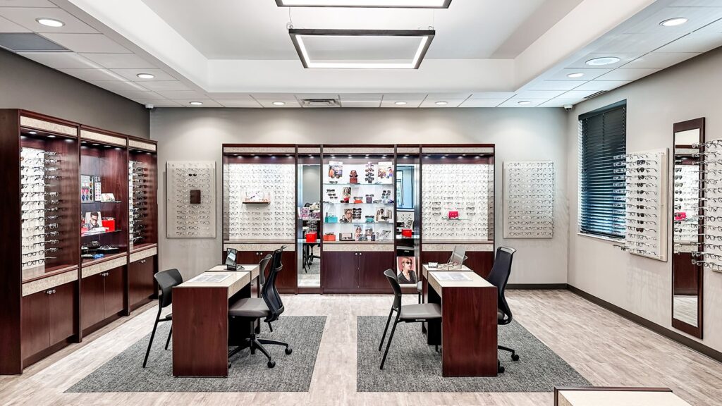 Open optical showroom with client consultation tables and retail shelving.