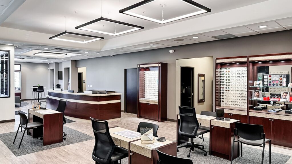 Front desk and optical retail space with warm wood finishes.
