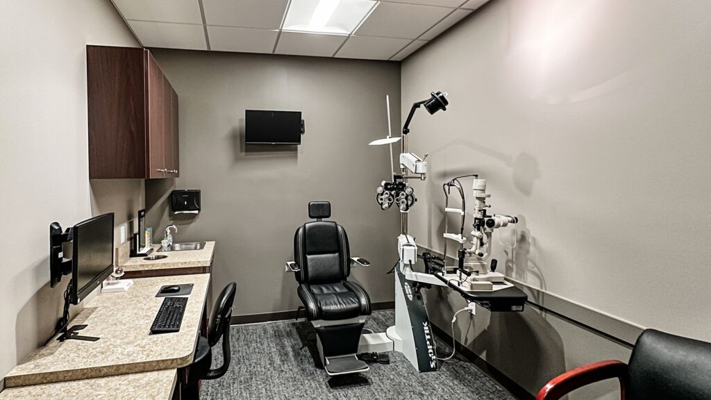 Eye exam room featuring diagnostic equipment and ergonomic seating.