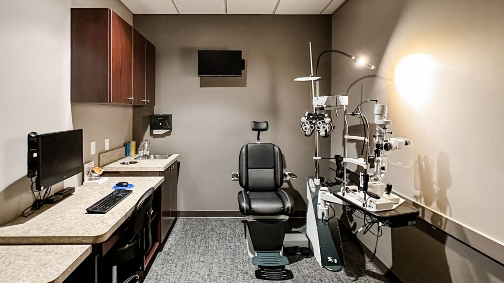 Eye exam room featuring diagnostic equipment and ergonomic seating.