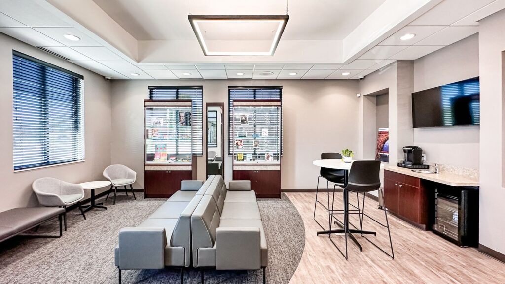 Lobby seating area with neutral furniture and large windows.