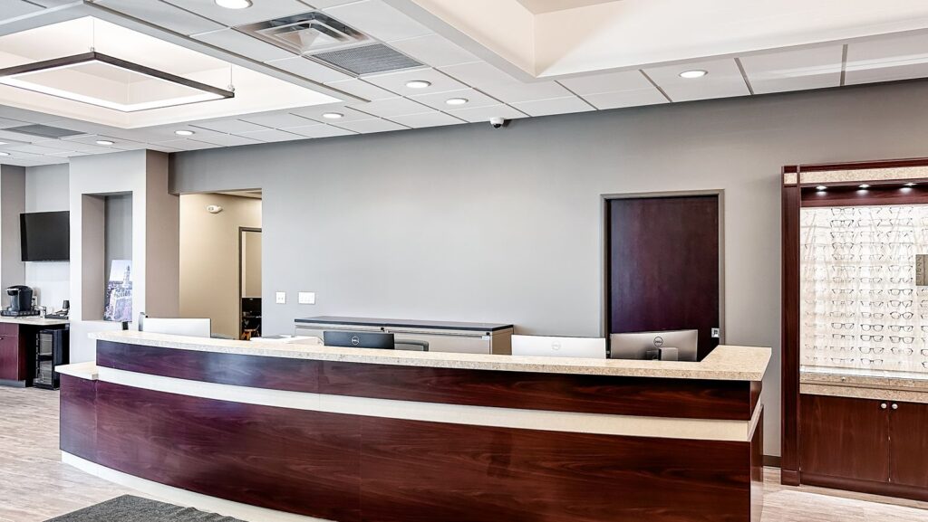 Optical retail area with eyeglass displays and modern office layout.