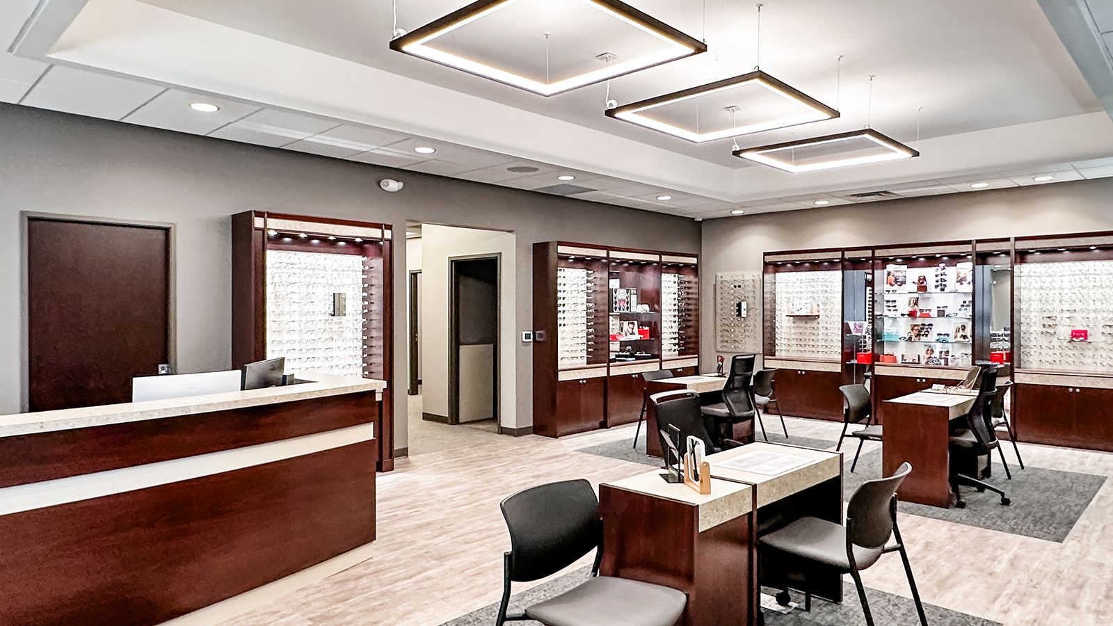 Optometry office reception area with wood accents and modern lighting design.