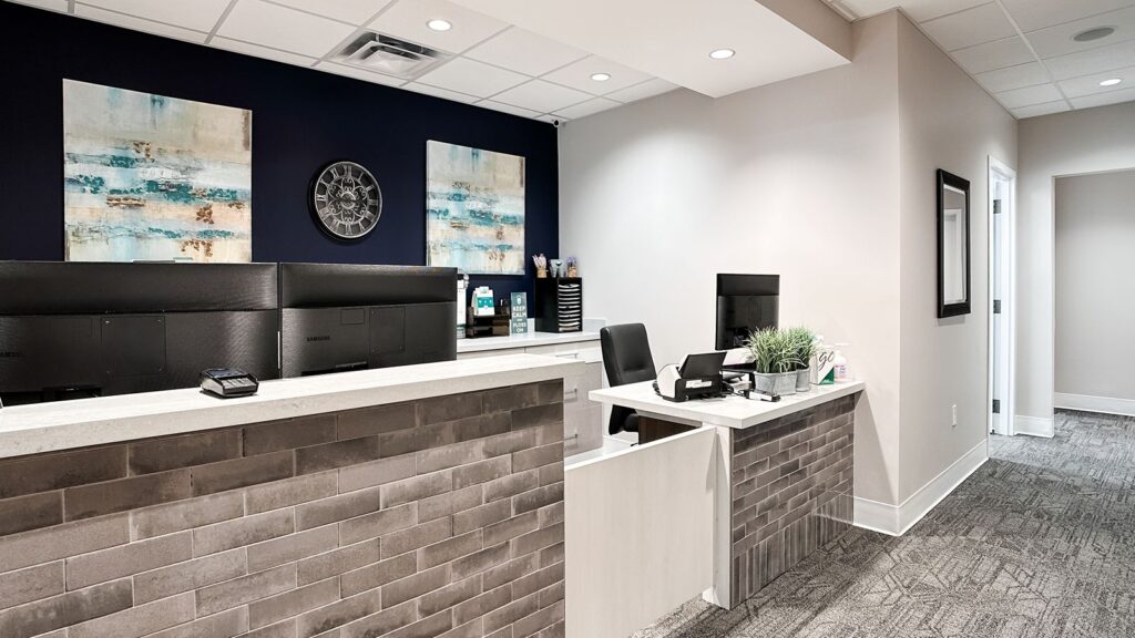 Reception area featuring brick accent wall and modern front desk design.
