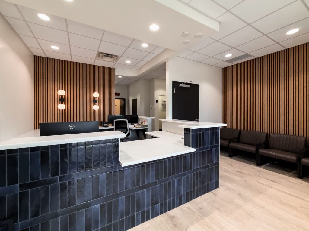 Front desk featuring modern navy tile and white quartz countertop.