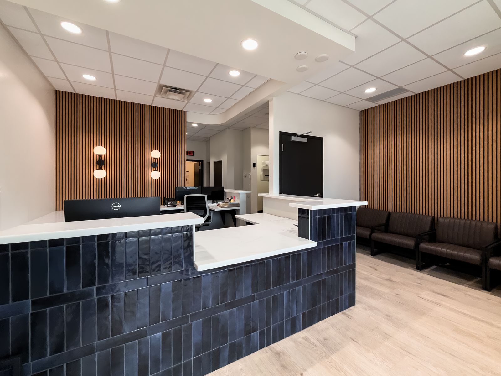 Dental office reception area with blue tile desk and seating.