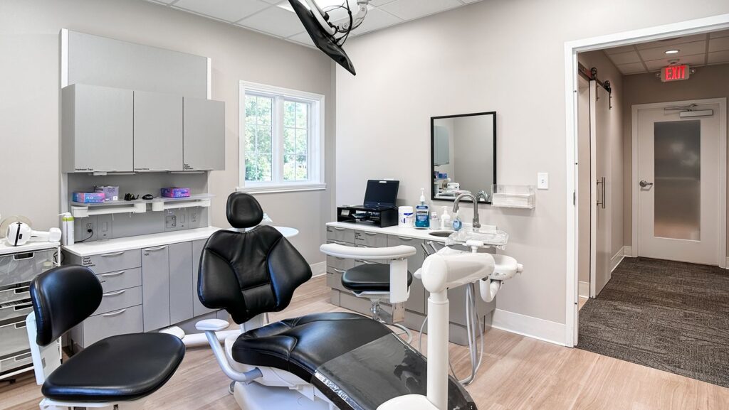 Family-friendly dental treatment room with window and child’s chair.