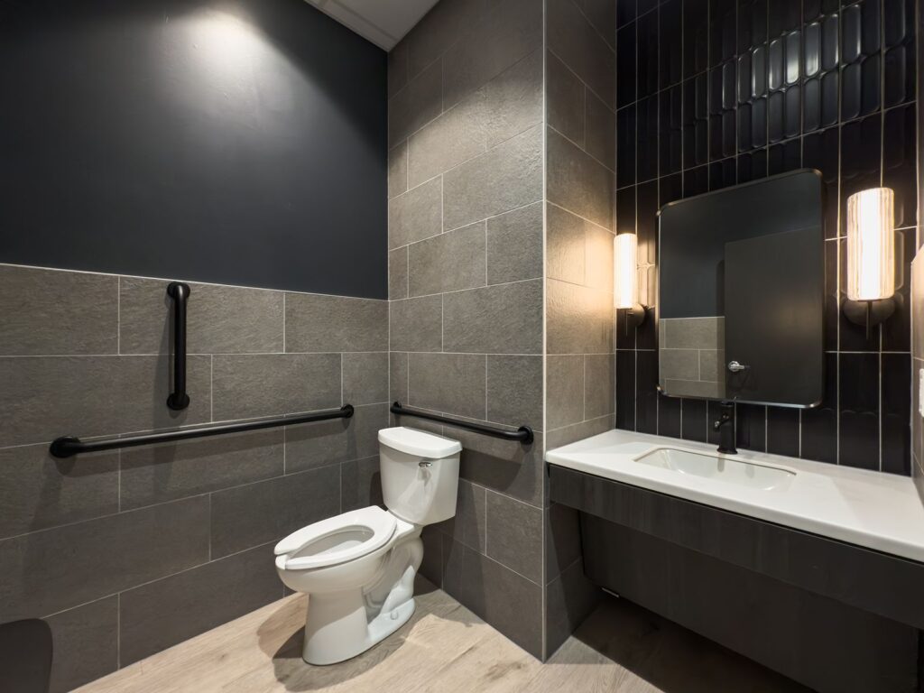 Restroom featuring modern tile and accessible layout.