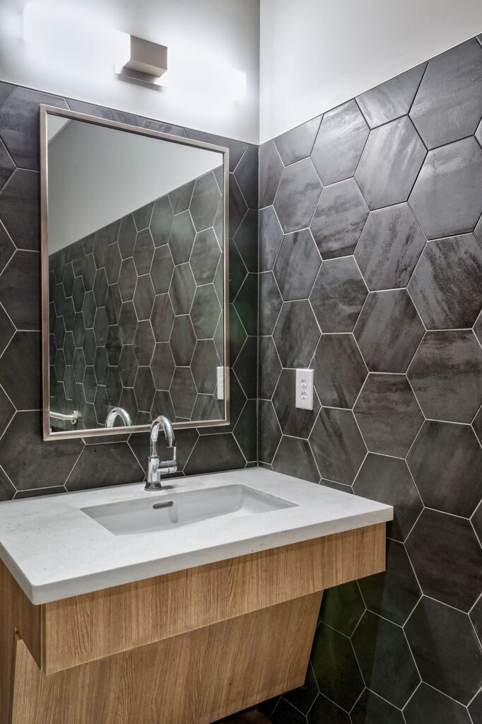 Modern dental office interior design featuring geometric tile patterns and custom vanity by healthcare architects.