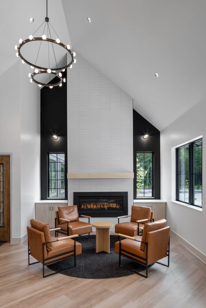 Interior waiting area with high vaulted ceiling, modern fireplace, and seating designed by healthcare architects.