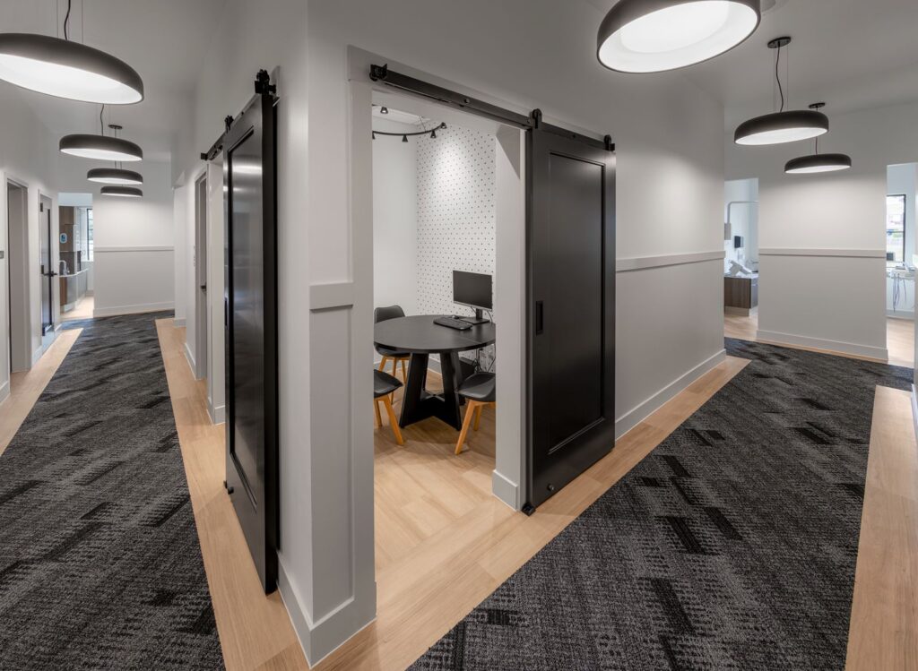 Hallway and workspace featuring contrasting wall textures by commercial interior design Indianapolis experts.