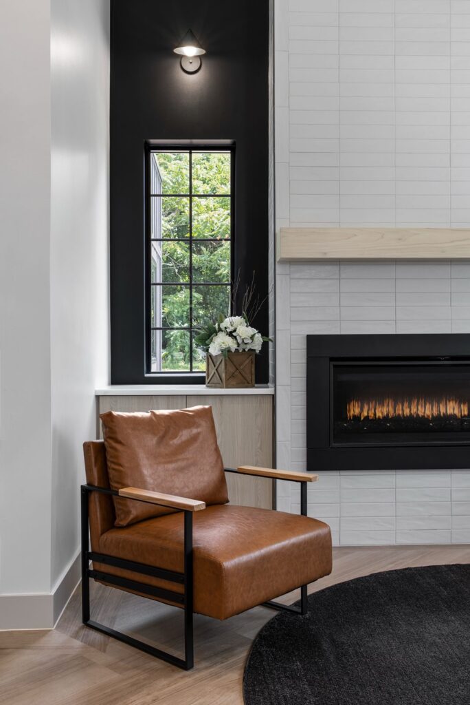 Seating area with leather chairs and fireplace showcasing warm, modern dental office decor.