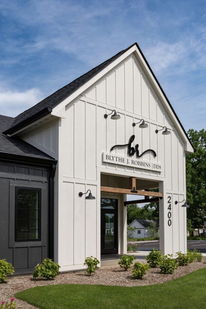Front entrance of Blythe J. Robbins DDS showcasing white board-and-batten siding and black modern trim.