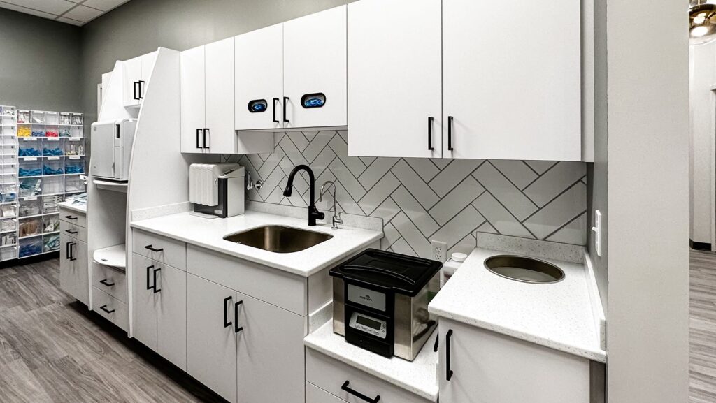 Dental lab featuring white cabinetry and herringbone backsplash for modern clinical flow.