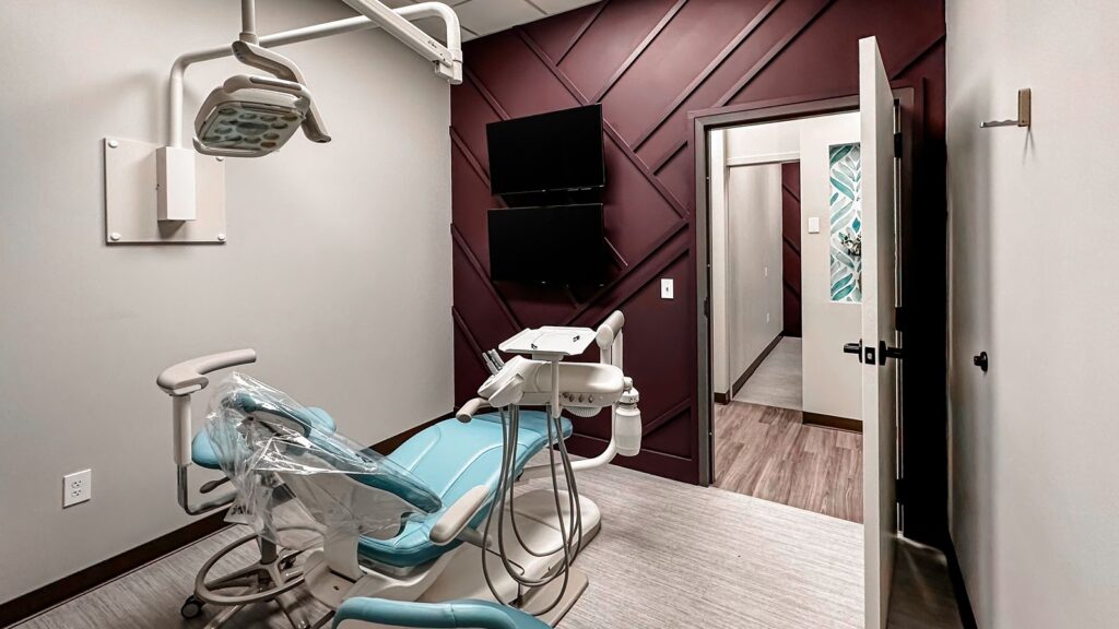 Private dental room with soft lighting and contrasting wall paneling for a modern aesthetic.