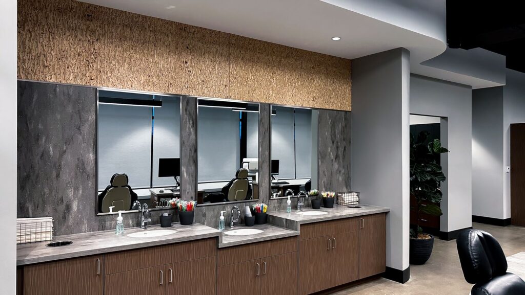 Open treatment bay with ergonomic dental chairs and large windows for natural light.