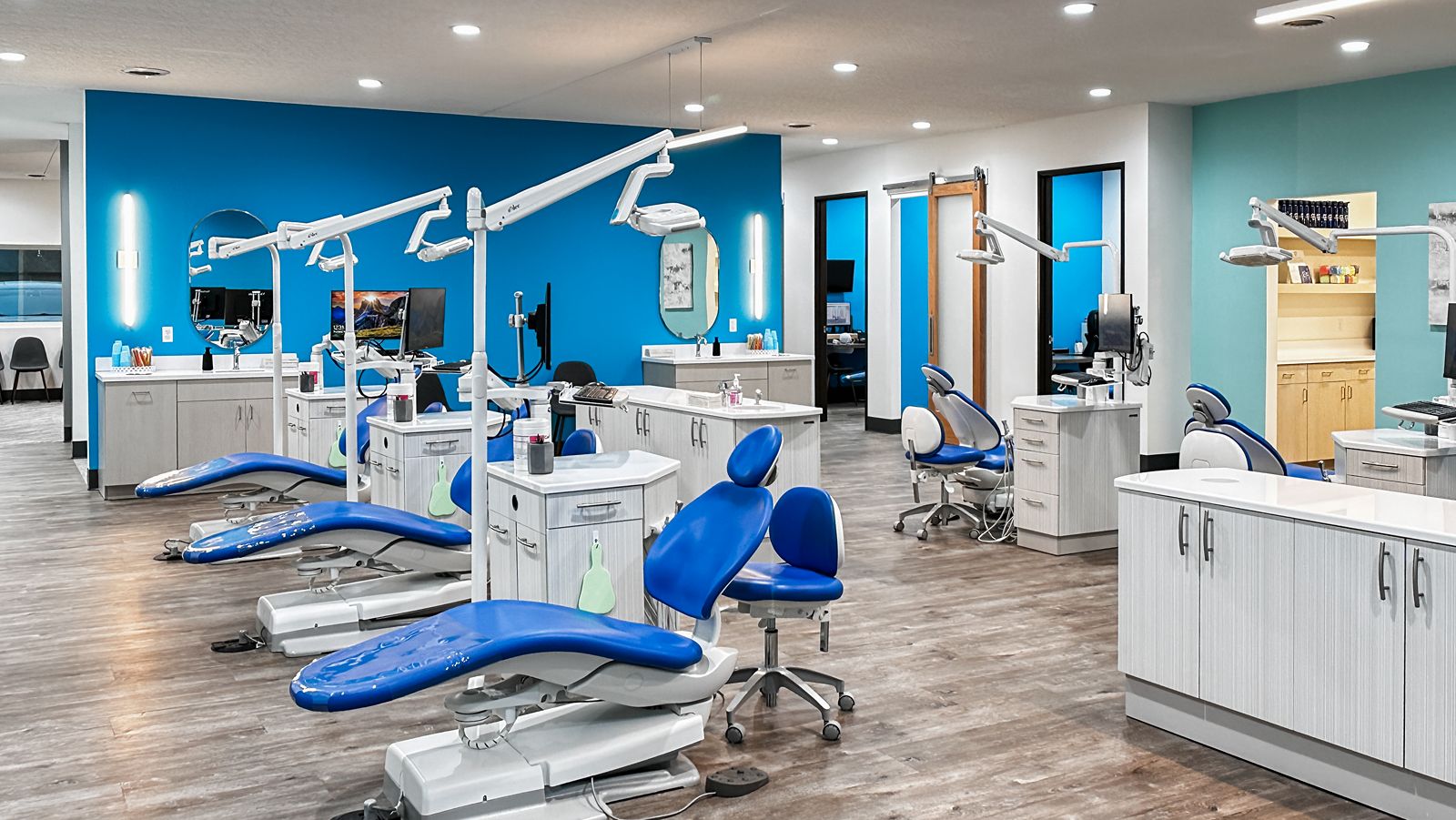 Open orthodontic treatment area featuring blue accent walls and modern dental chairs.