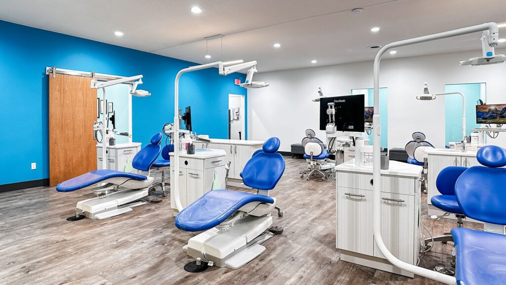 Orthodontic treatment area with blue walls, wood flooring, and modern cabinetry.