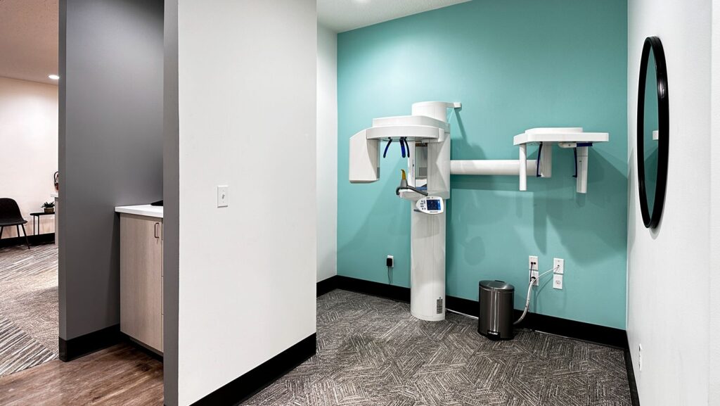 Imaging area featuring panoramic dental X-ray machine and teal accent wall.