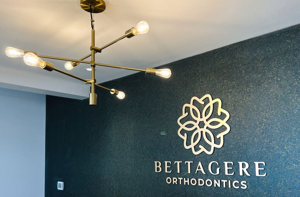 Lobby chandelier and branding wall showcasing modern orthodontic office design and interior designer Indianapolis craftsmanship.