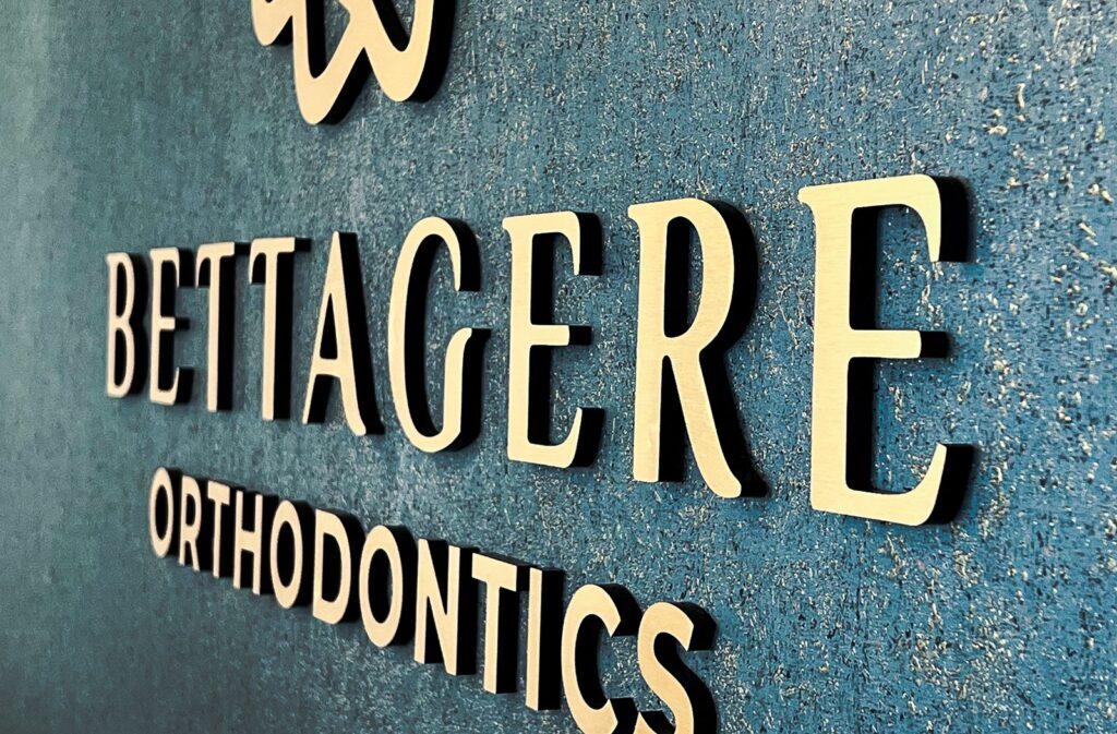 Close-up of gold signage and textured blue feature wall reflecting dental office branding design.