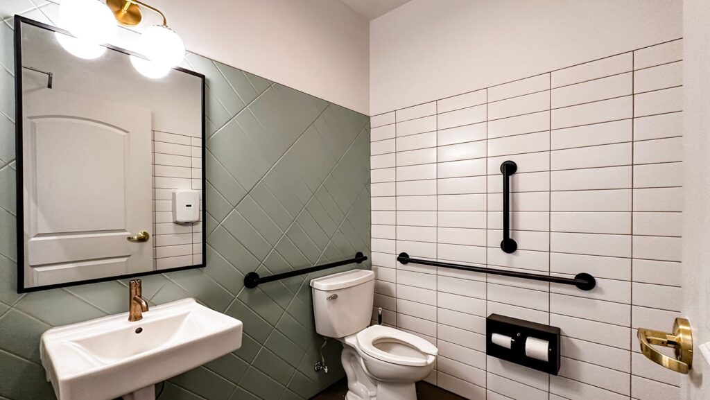 Restroom with geometric tile walls and ADA-compliant fixtures designed by interior designer Indianapolis.