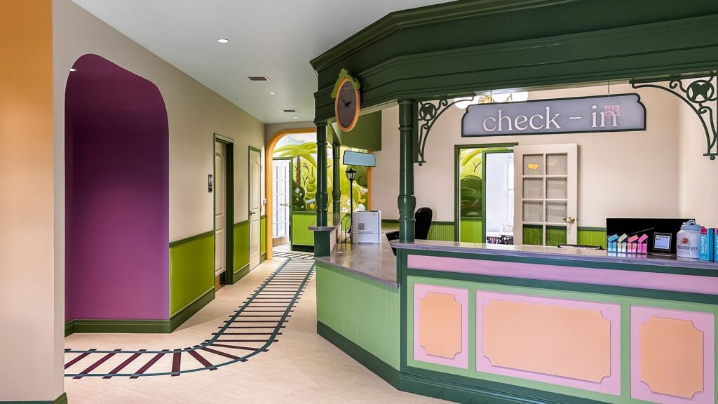 Purple entry door and colorful hallway showcasing playful pediatric dental clinic interior design and curated wall art.