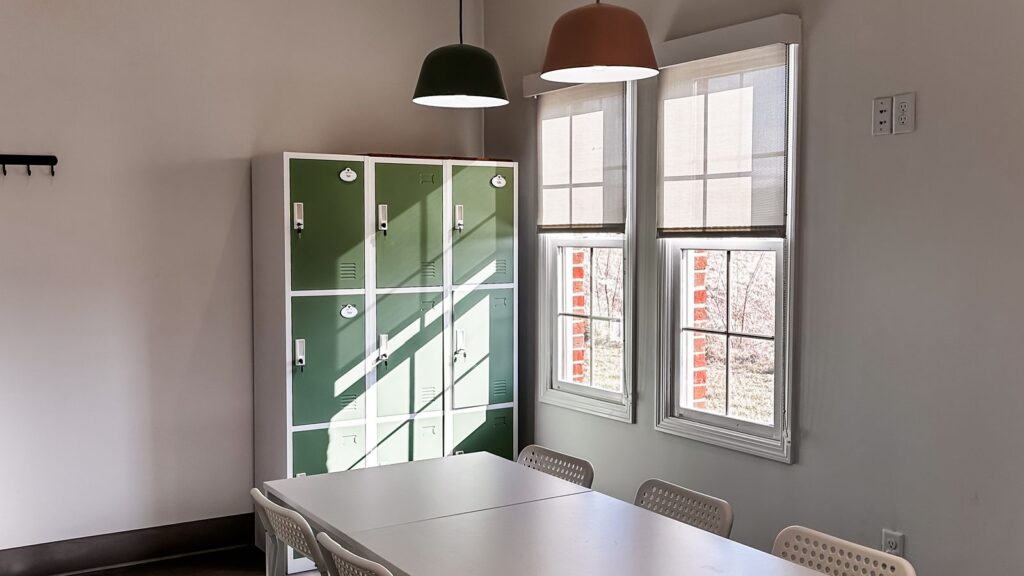 Staff lounge with green lockers and pendant lighting created through thoughtful dental office architecture planning.