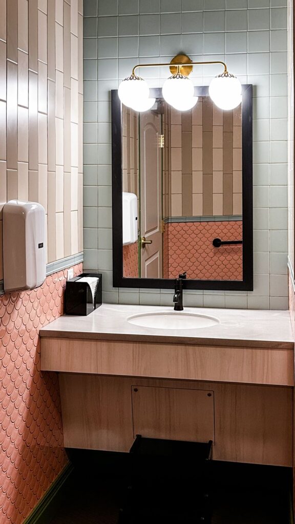 Restroom featuring coral and beige tile walls designed by dental architects with modern accessibility features.